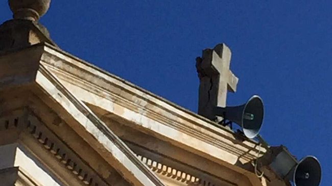 La croce della chiesa del cimitero sta per crollare. Nessuno se ne accorge. Deve scapparci il morto?